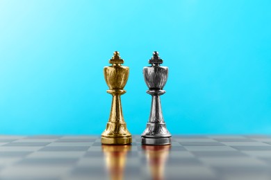 Photo of Golden and silver chess kings in middle of chessboard. Competition concept