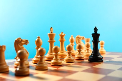 Photo of Black king in front of other white chess pieces on chessboard. Competition concept