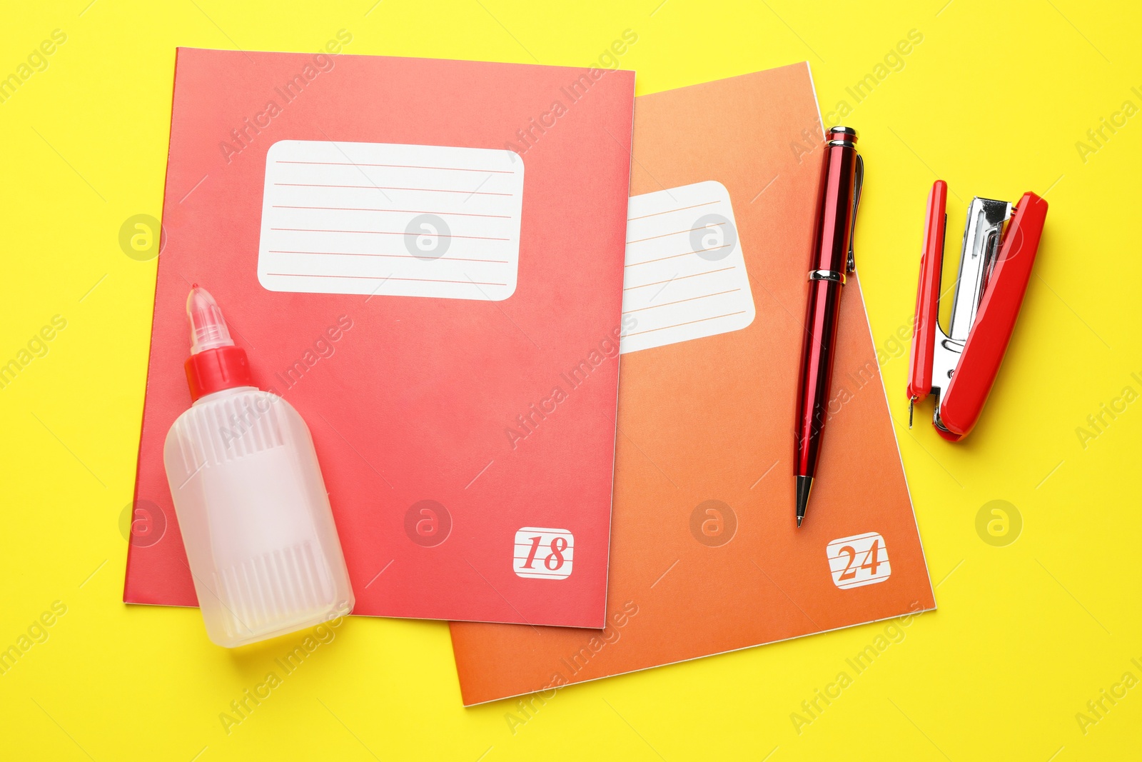 Photo of Flat lay composition with copybooks and other school stationery on yellow background