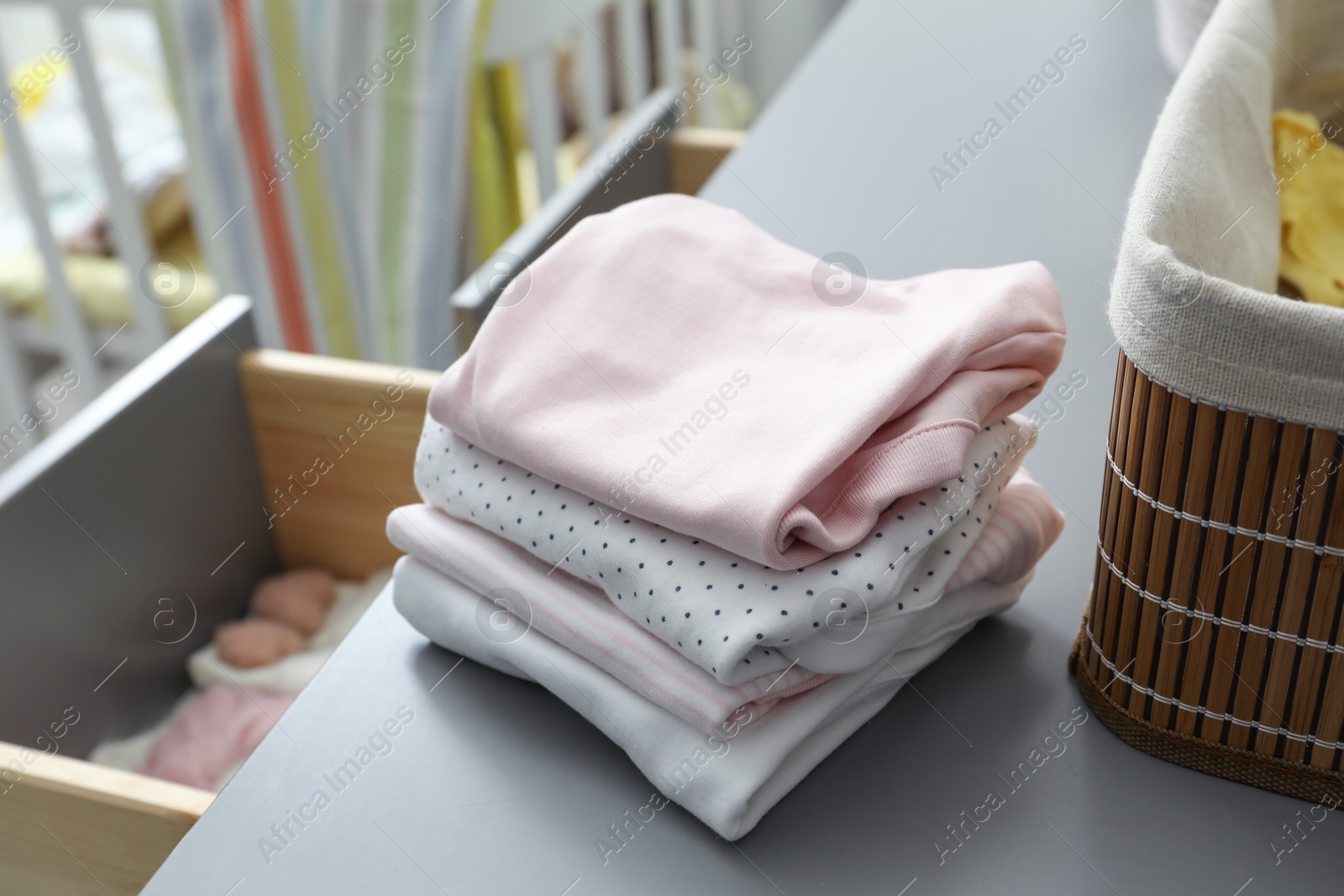 Photo of Baby clothes on gray chest of drawers indoors