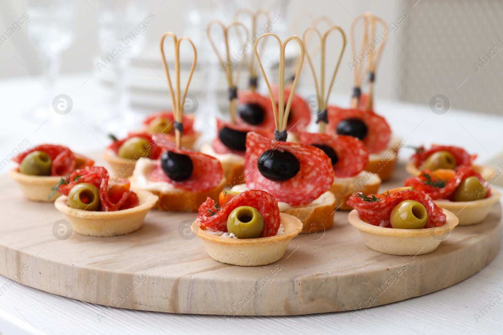 Photo of Many different tasty canapes on white wooden table, closeup