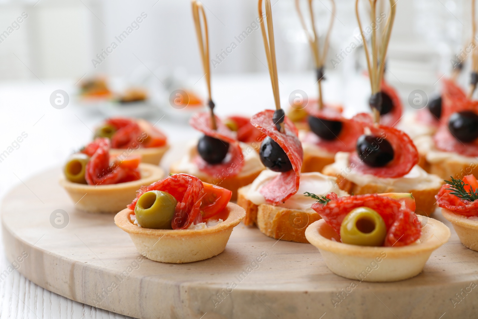 Photo of Many different tasty canapes on white wooden table, closeup