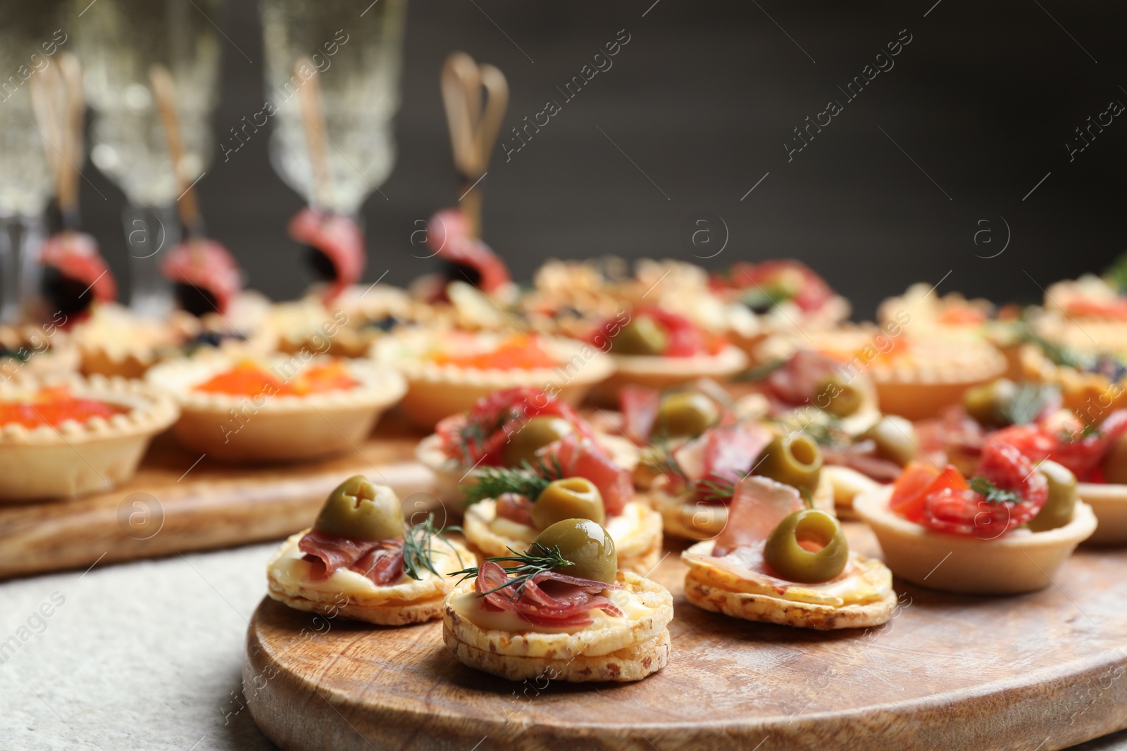 Photo of Many different tasty canapes and wine on white table, closeup