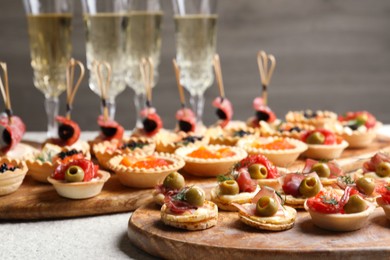 Photo of Many different tasty canapes and wine on white table, closeup