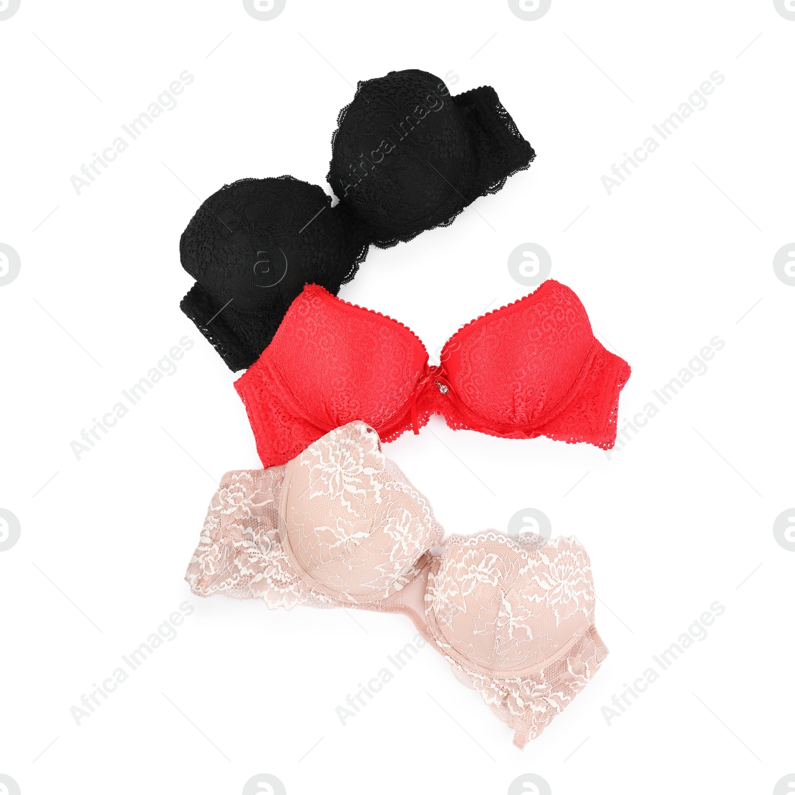 Photo of Three different beautiful bras isolated on white, top view