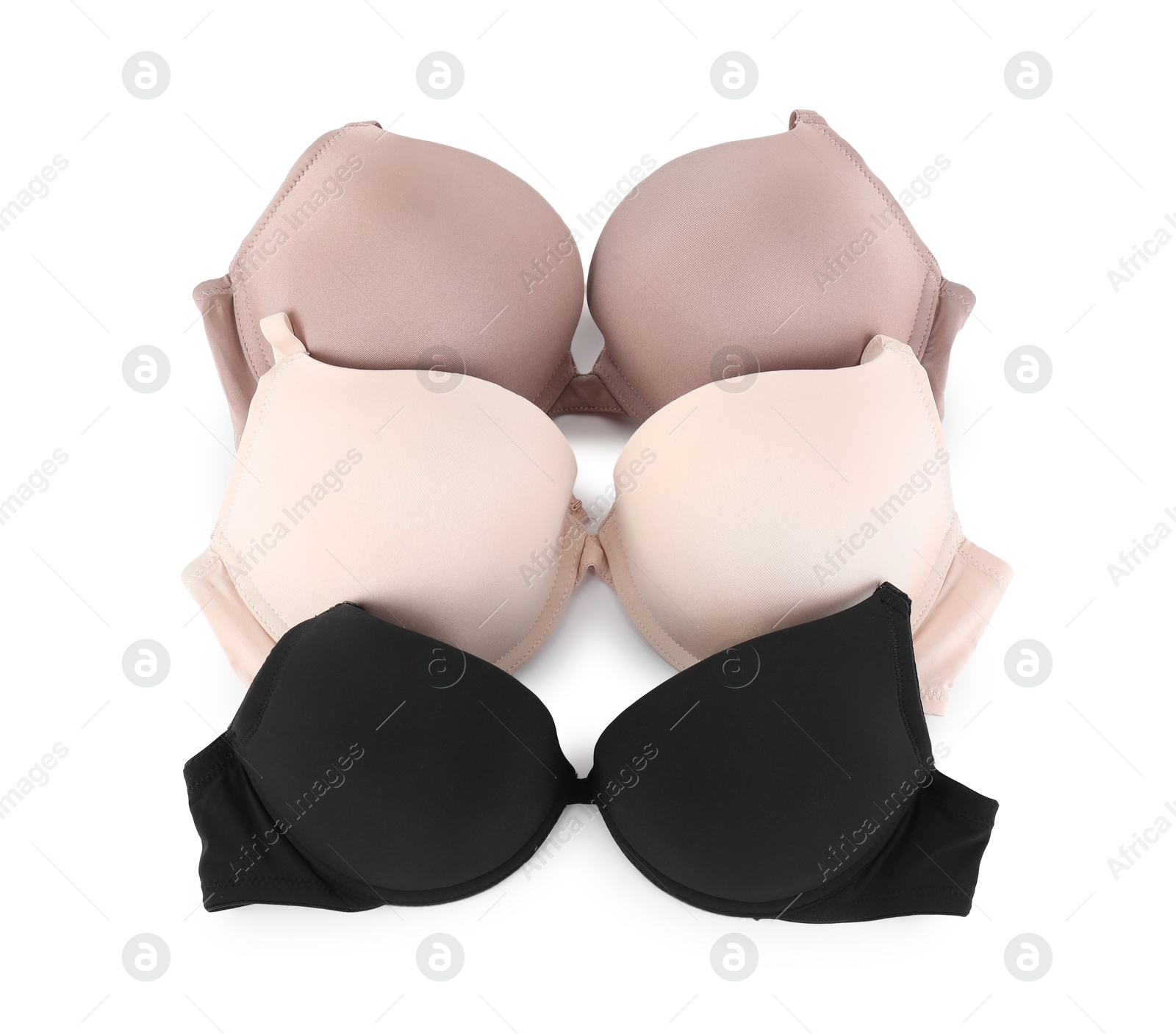 Photo of Three different beautiful bras isolated on white, top view