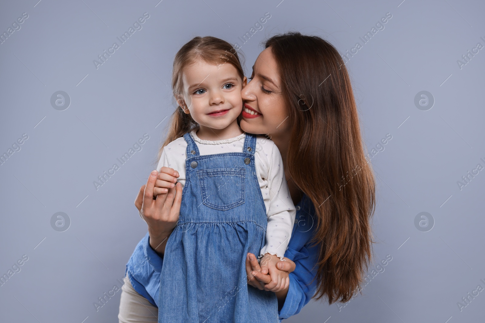 Photo of Happy mother with her cute little daughter on grey background