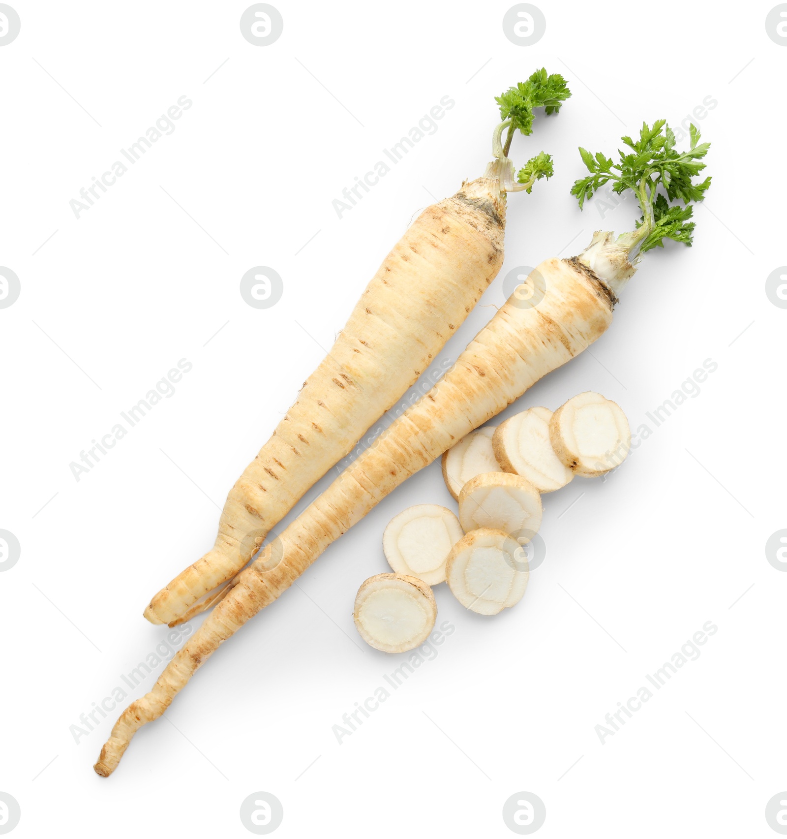 Photo of Whole and cut fresh parsley roots isolated on white, top view