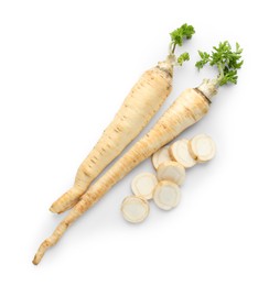 Photo of Whole and cut fresh parsley roots isolated on white, top view