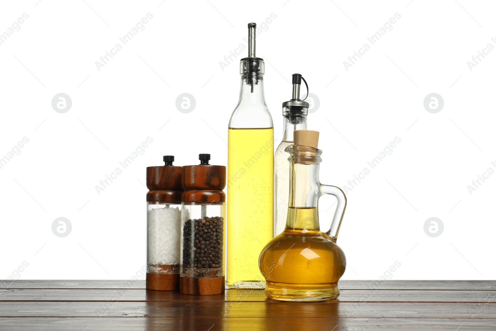 Photo of Salad dressings and spices on wooden table against white background