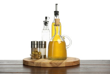 Photo of Salad dressings, olives and spices on wooden table against white background