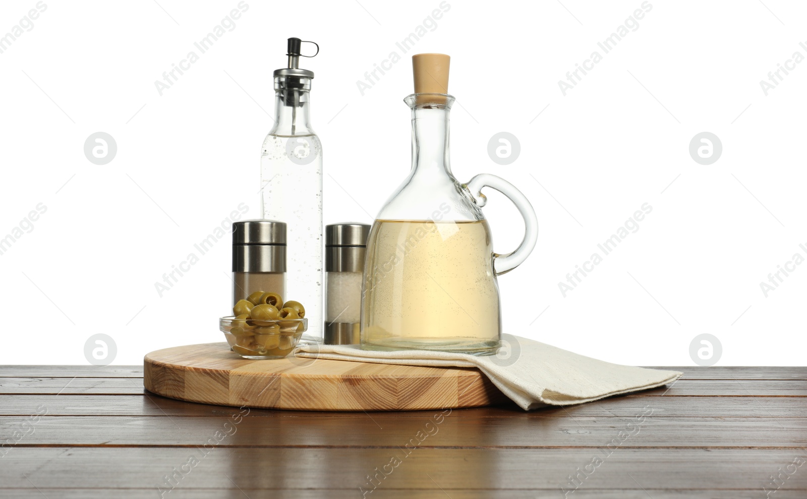 Photo of Salad dressings, olives and spices on wooden table against white background