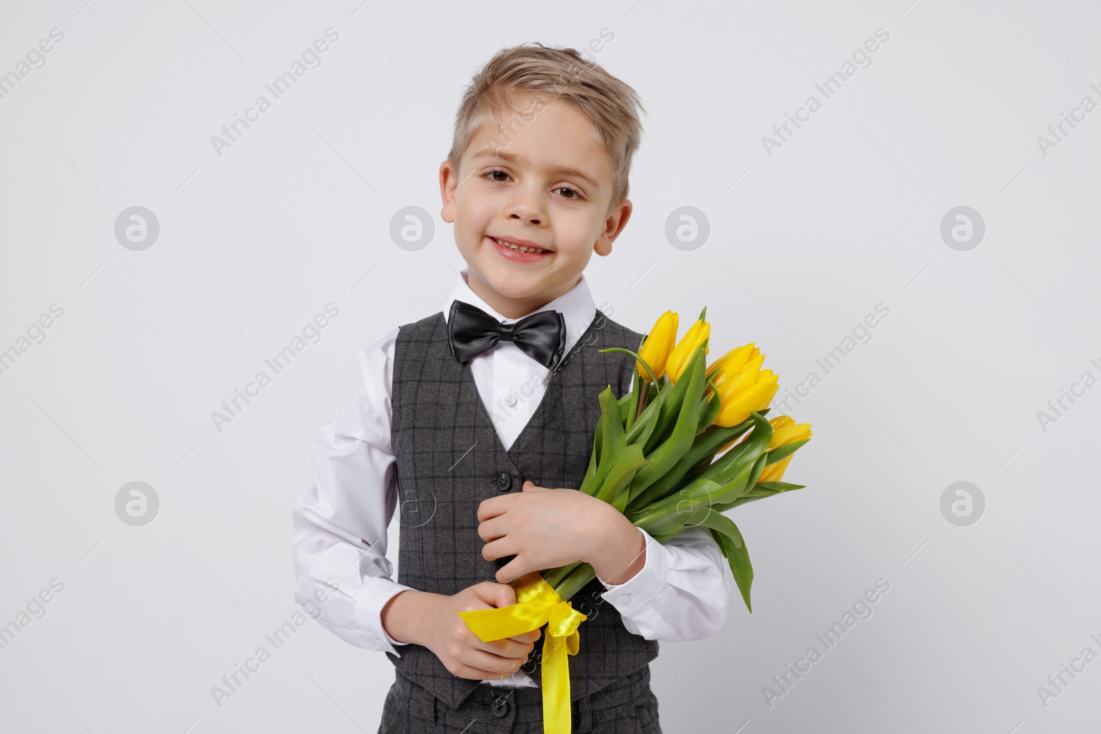 Photo of Cute little boy with bouquet of tulips on white background