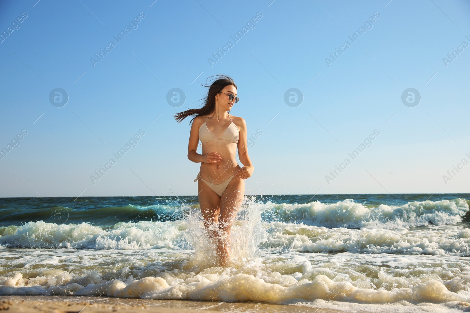 Photo of Beautiful young woman with attractive body on beach