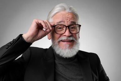 Happy senior man on light grey background