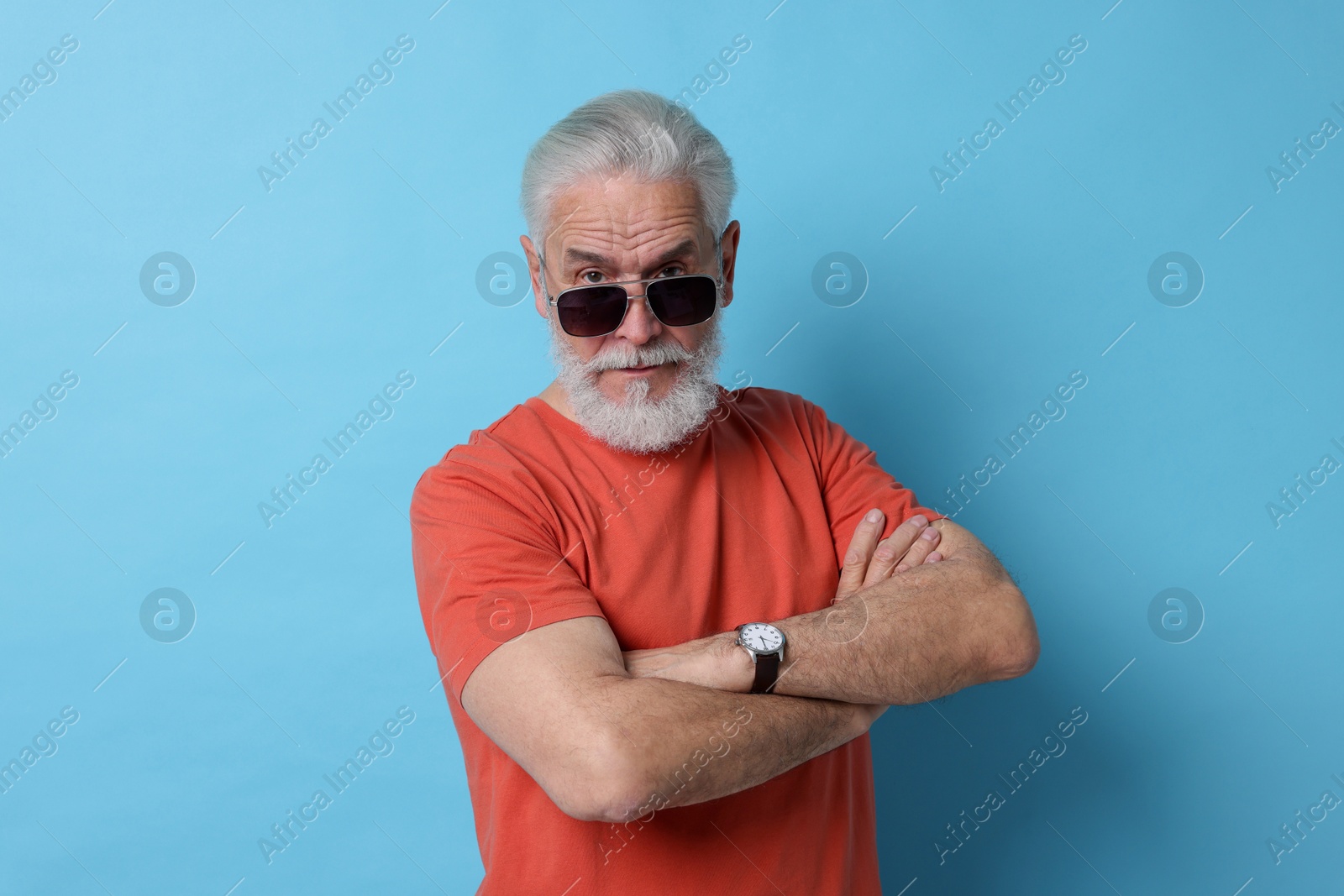 Photo of Senior man in sunglasses on light blue background