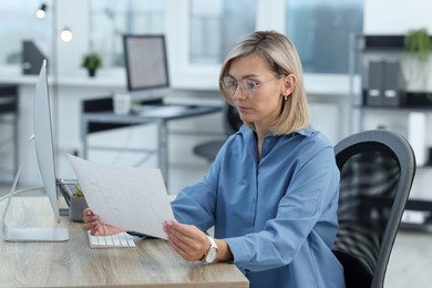 Technician making digital engineering drawing on computer at desk in office