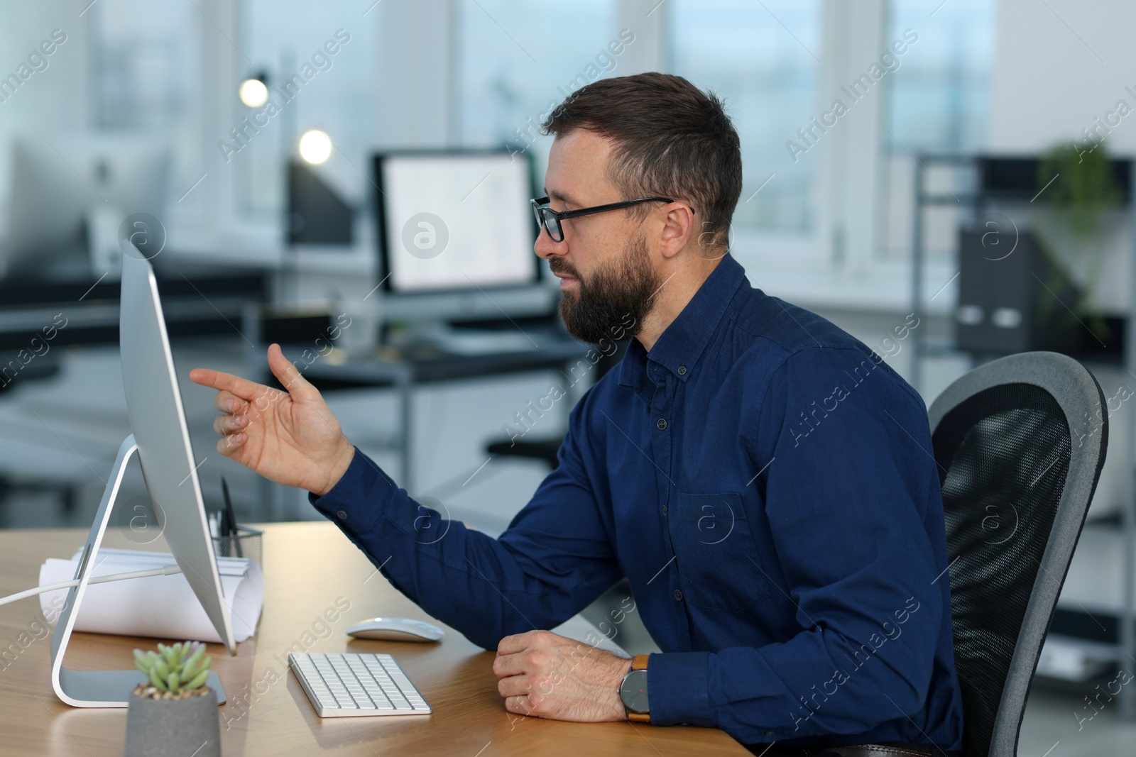 Photo of Technician making digital engineering drawing on computer at desk in office