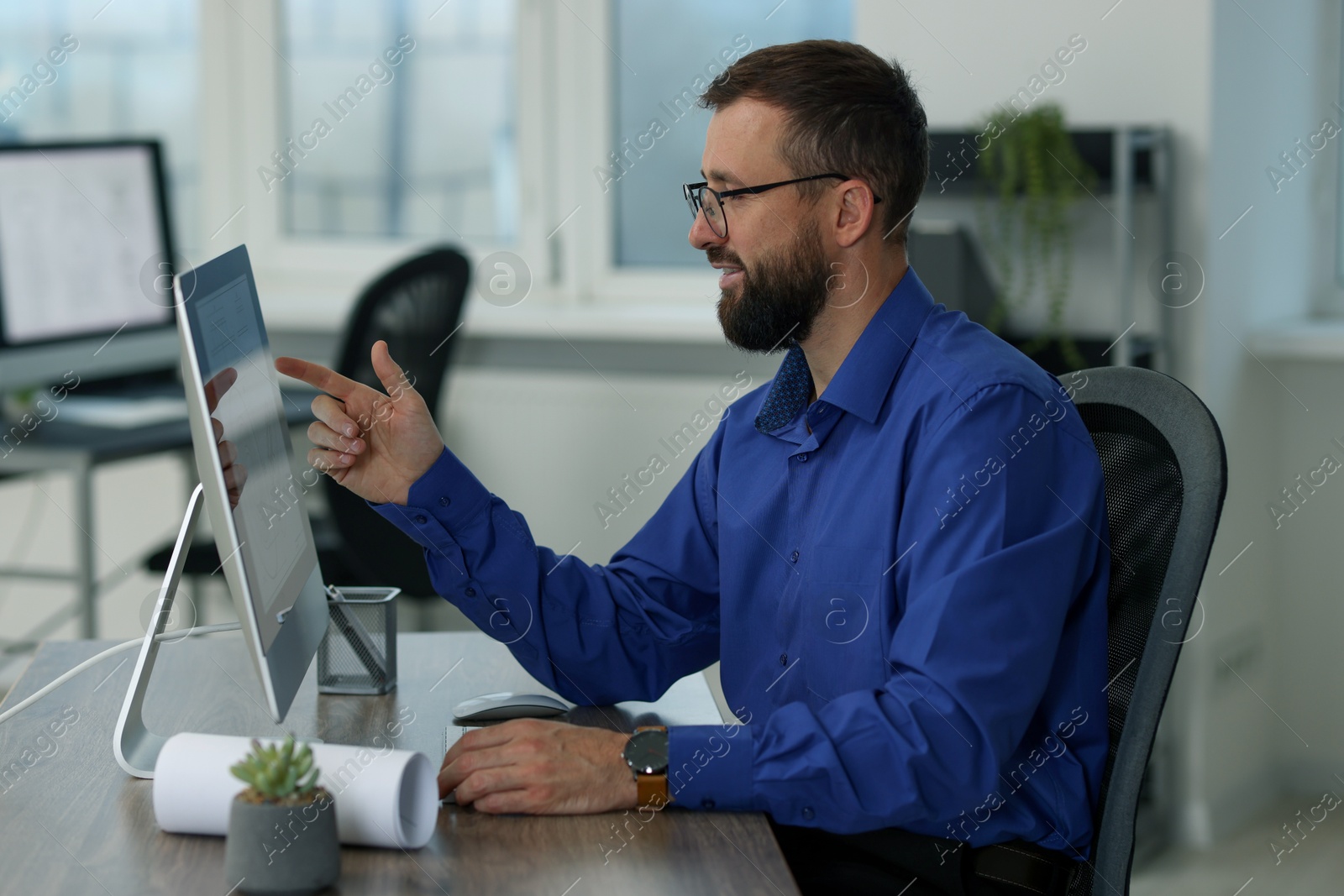 Photo of Technician making digital engineering drawing on computer at desk in office