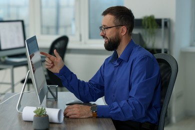 Photo of Technician making digital engineering drawing on computer at desk in office