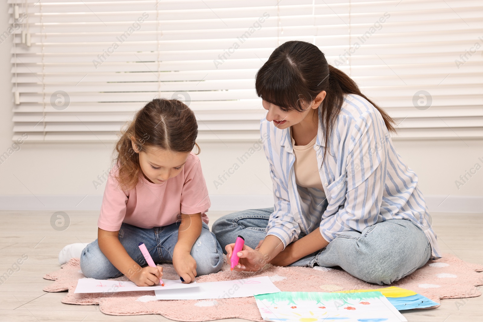 Photo of Autism therapy. Smiling psychologist and little girl drawing pictures in mental health center