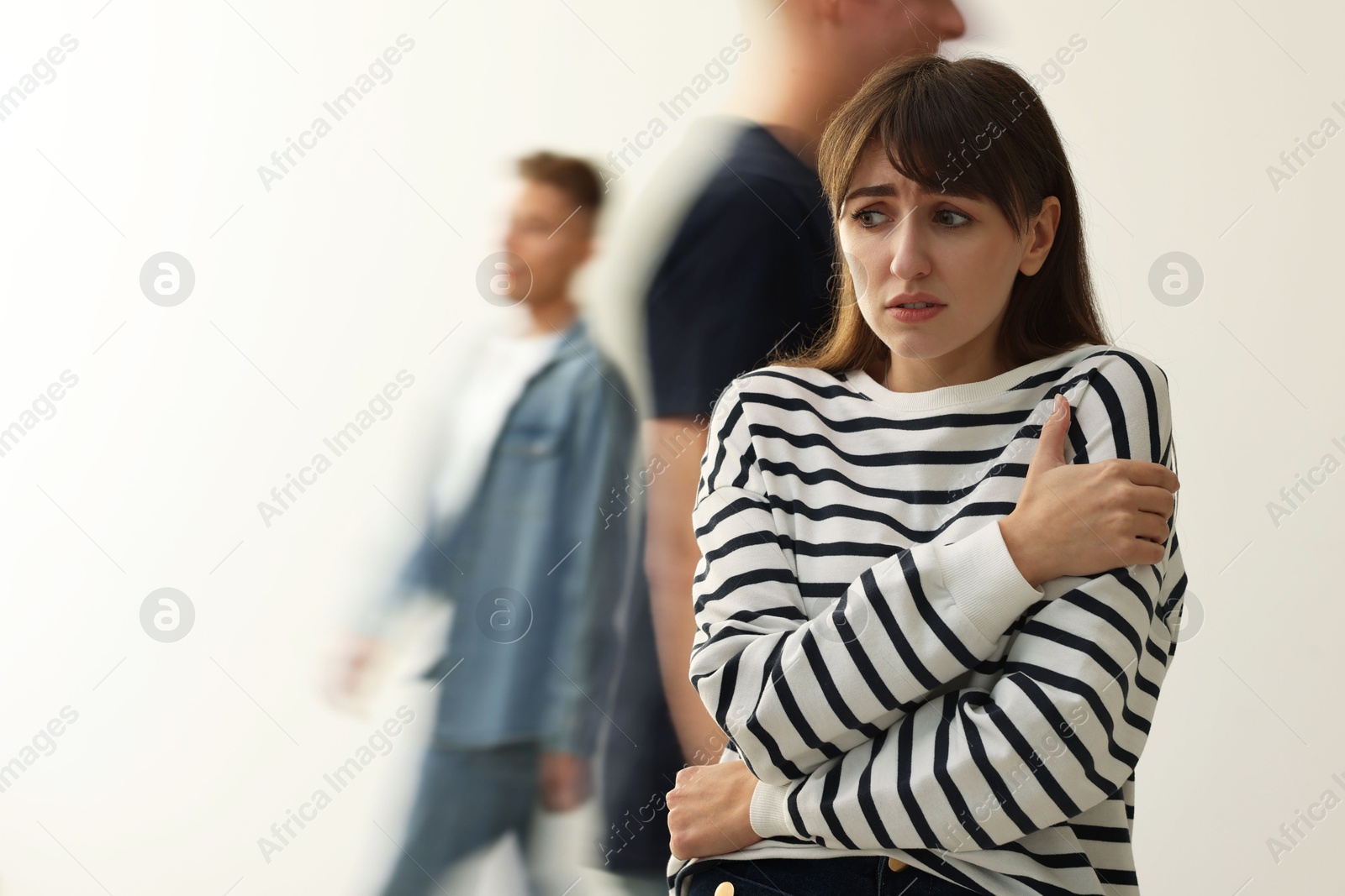 Photo of Young woman feeling uncomfortable among people indoors