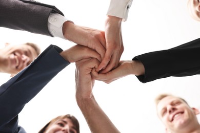 Photo of Teamwork. Group of people joining hands together indoors, bottom view