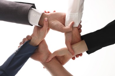 Photo of Teamwork. Group of people joining hands together indoors, bottom view