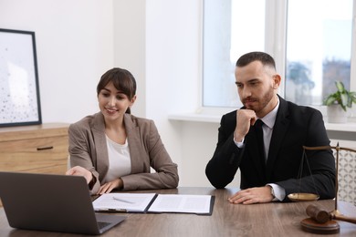 Photo of Man having meeting with professional notary at wooden desk indoors