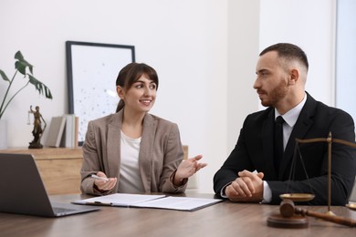 Photo of Man having meeting with professional notary at wooden desk indoors