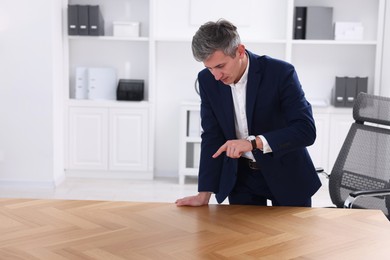 Photo of Man pointing at something on desk in office. Space for text