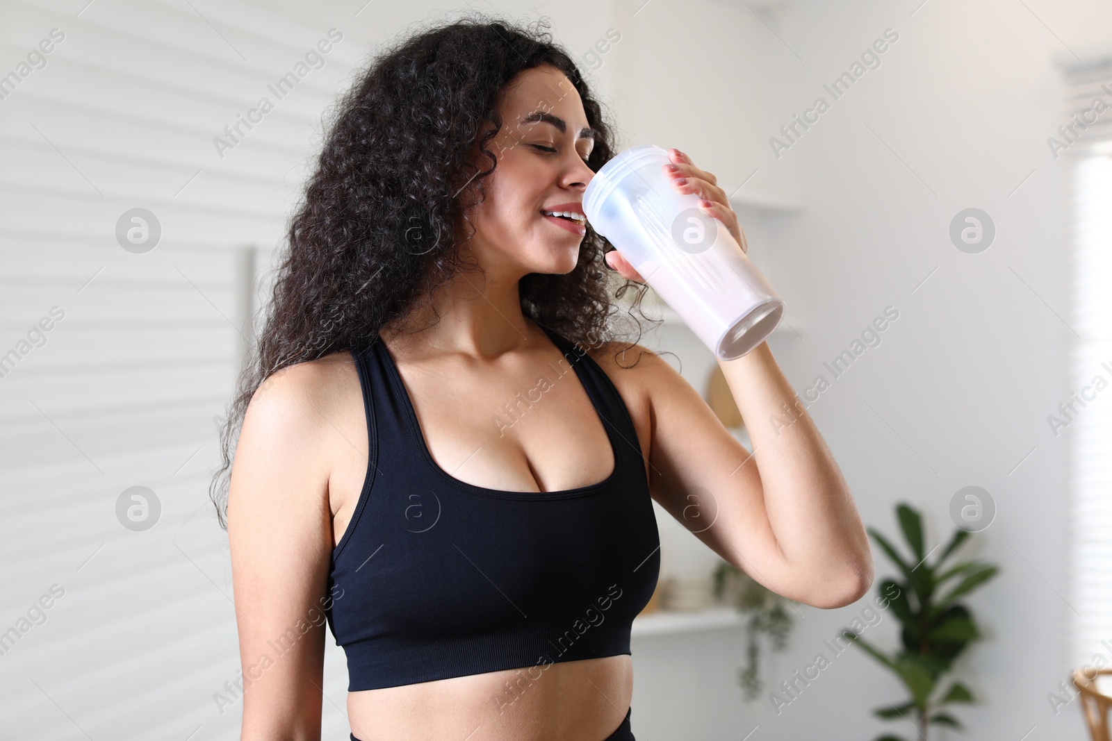 Photo of Beautiful woman drinking protein shake at home