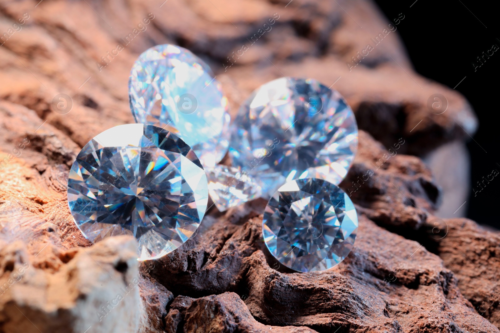 Photo of Beautiful shiny gemstones on stone, closeup view