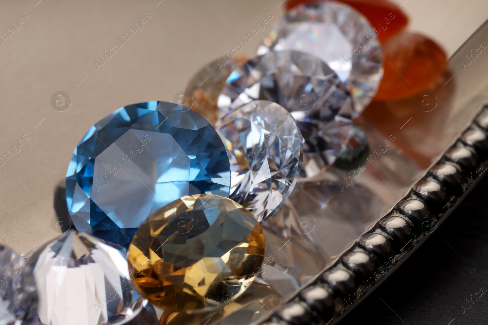 Photo of Beautiful shiny colorful gemstones on light background, closeup