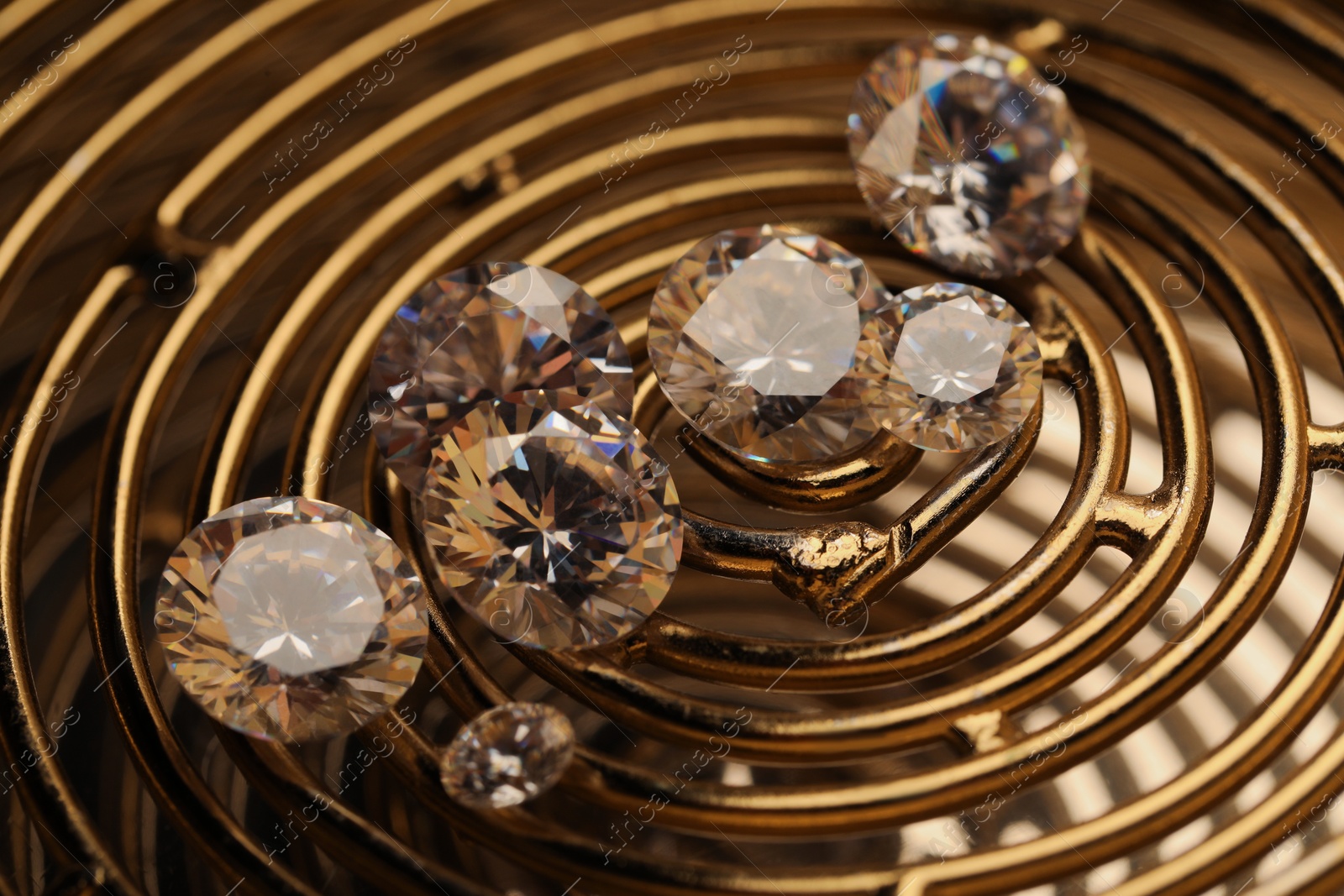 Photo of Beautiful shiny gemstones on golden tray, closeup