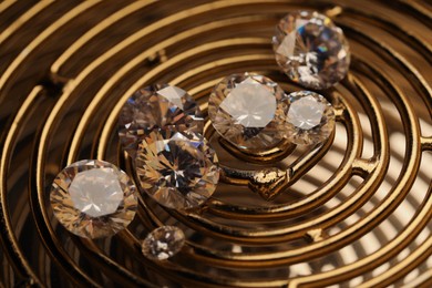 Photo of Beautiful shiny gemstones on golden tray, closeup