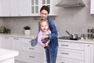 Photo of Housewife playing with her little daughter in kitchen