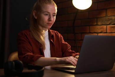 Photo of Woman working with laptop at table in office