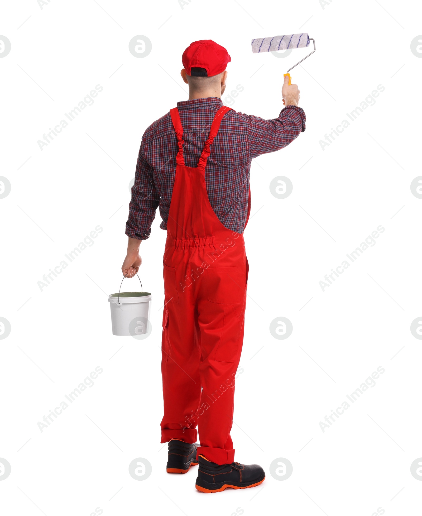 Photo of Professional painter with roller and bucket of paint working on white background, back view