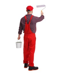 Photo of Professional painter with roller and bucket of paint working on white background, back view