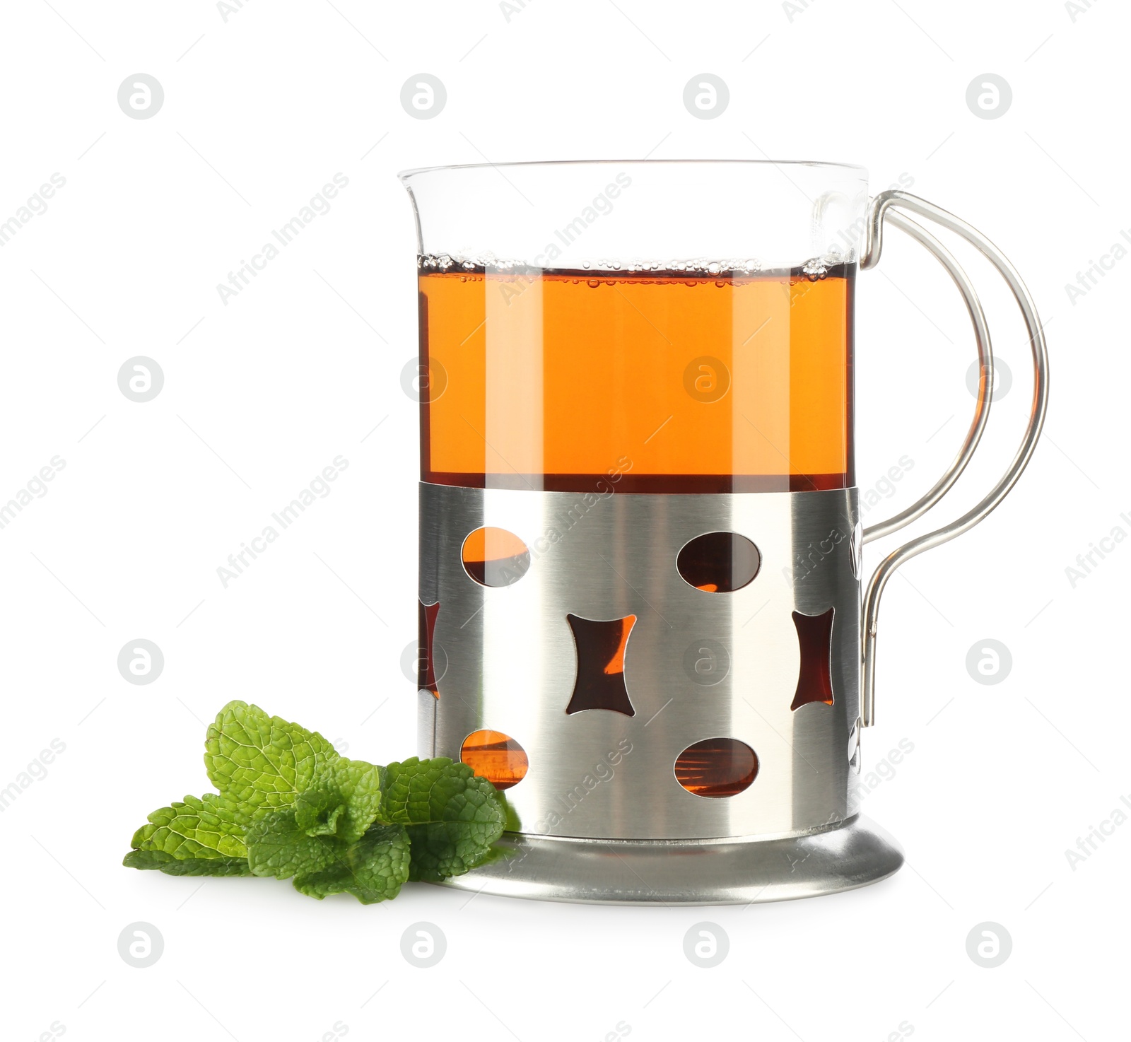 Photo of Glass of aromatic tea in holder and mint isolated on white