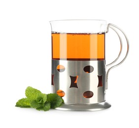 Photo of Glass of aromatic tea in holder and mint isolated on white