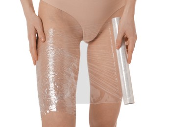 Photo of Woman doing spa body wraps on her leg against white background, closeup