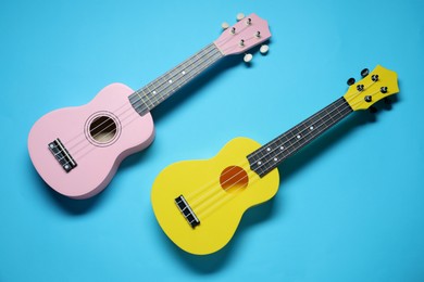 Photo of Two ukuleles on light blue background, top view