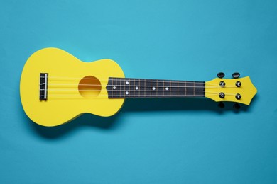 Photo of One ukulele on light blue background, top view