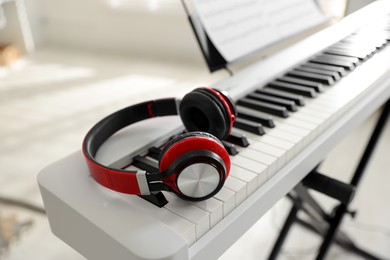 Photo of Synthesizer with music sheet and headphones indoors, closeup