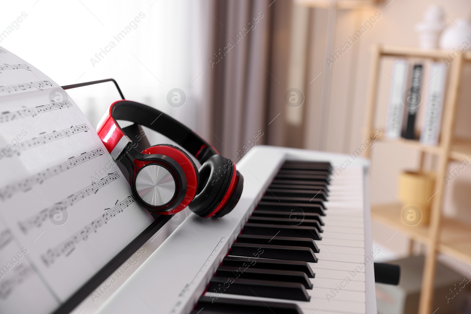 Photo of Synthesizer with music sheet and headphones indoors, closeup