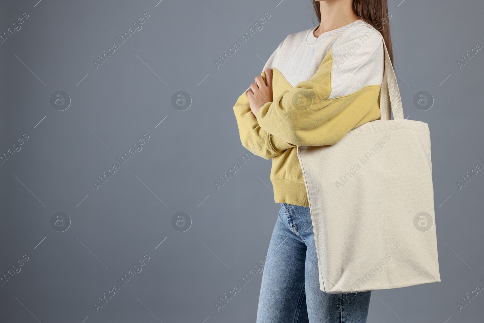 Photo of Woman with blank shopper bag on grey background, closeup. Mockup for design