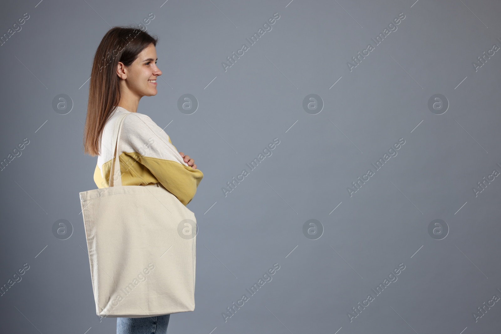 Photo of Woman with blank shopper bag on grey background. Mockup for design