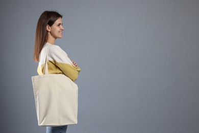 Photo of Woman with blank shopper bag on grey background. Mockup for design